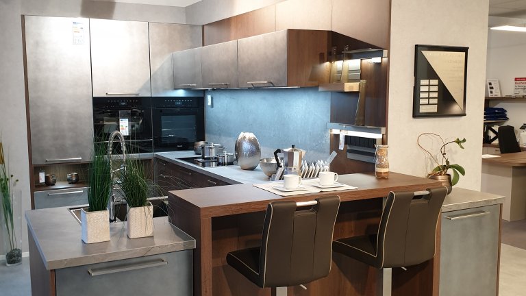 Moderne Häcker U-Küche mit extravaganter Planung. Fronten Metallic kombiniert mit Alteiche Cognac Nachbildung. Die Küche ist mit hochwertigen Miele Einbaugeräten ausgestattet.